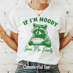 a woman wearing a t - shirt that says if i'm moody give me foody