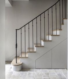 a white staircase with black railing and handrails in an empty room next to a wall