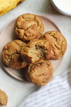 several muffins on a plate next to a banana