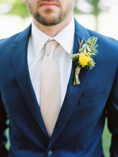 a man wearing a suit and tie with a boutonniere on his lapel