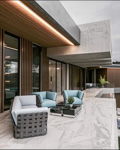 two chairs and a table in front of a building with glass doors on the outside