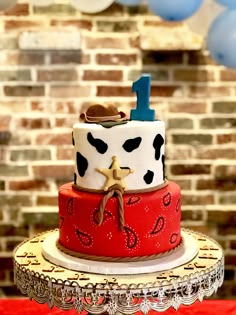 a three tiered cake decorated with red, white and blue decorations on a table