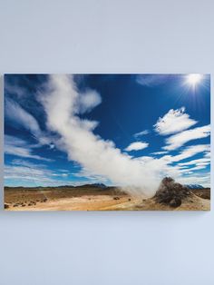 a geyser spewing out steam into the sky on a sunny day