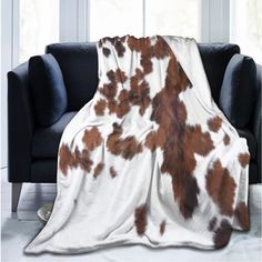 a cow print blanket is draped over a couch