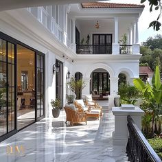 an outdoor patio with chairs and potted plants