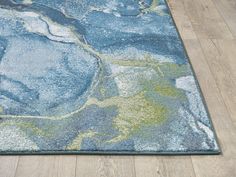 a blue area rug with an abstract design on the bottom and green, yellow, and white areas