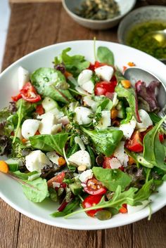 a white bowl filled with salad on top of a wooden table