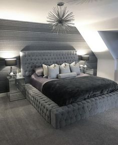 a large bed sitting in the middle of a bedroom next to two lamps on either side of it