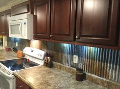 a kitchen with brown cabinets and marble counter tops, white stove top oven and microwave