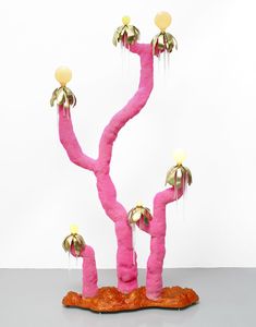 a pink sculpture with gold decorations on it's branches and two yellow balls hanging from the top