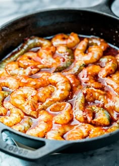 a skillet filled with cooked shrimp and sauce