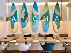 a restaurant with surfboards mounted on the wall and wooden tables in front of them