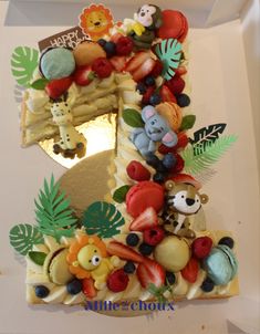 the number one cake is decorated with fruits and animals