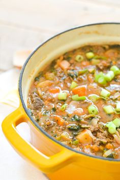 a yellow pot filled with soup on top of a table