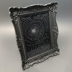 an ornate silver frame with a spider web in the center