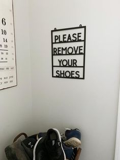 there is a pile of shoes on the floor next to a wall with a sign that says please remove your shoes