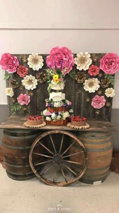 a table with flowers on it and a wooden barrel as the base for a cake