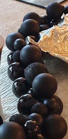 chocolate covered donuts are lined up in a row on the table next to a piece of tin foil