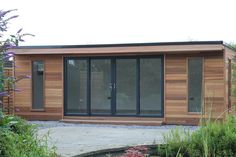 a small wooden building sitting in the middle of a garden