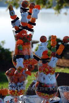 halloween candy in glass vases sitting on top of a table