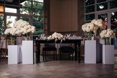 white flowers in vases sitting on top of a table with the name thomas written on it