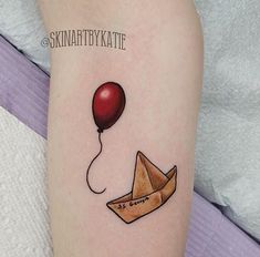 a tattoo on the arm of a woman with an envelope and balloon flying in the sky