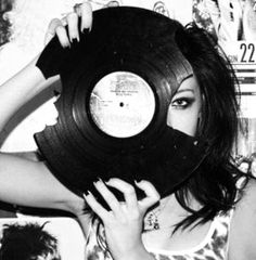 a woman holding up a record in front of her face