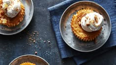 three small desserts on plates with whipped cream