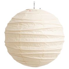 a large white paper lantern hanging from a hook on a string with an attached cord