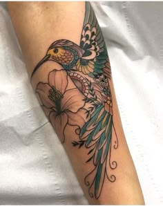 a bird with wings and flowers on the arm