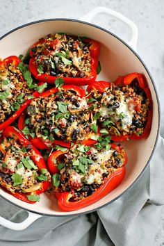 stuffed bell peppers with black beans and herbs in a white pan on a gray surface