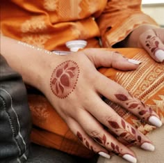 a woman's hand with henna tattoos on it