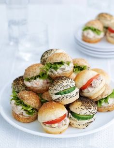 small sandwiches are piled on top of each other in the middle of a white plate