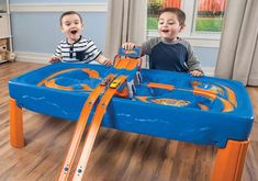 two young boys playing with a toy train set