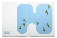 there are many birds flying together in the sky and on the letter h that is made out of paper