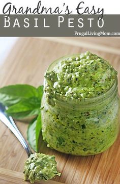 a wooden cutting board topped with a jar of pesto