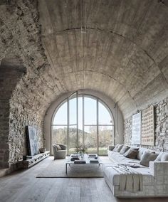 a living room filled with lots of furniture and large windows in the middle of it