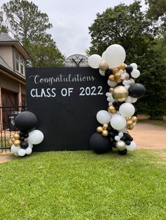 graduation balloon arch with black and white balloons on the front lawn at congratulations class of 2020