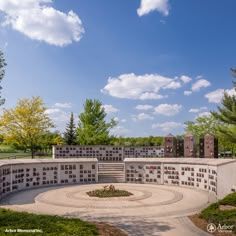 a circular stone structure with many windows on the side and trees in the back ground