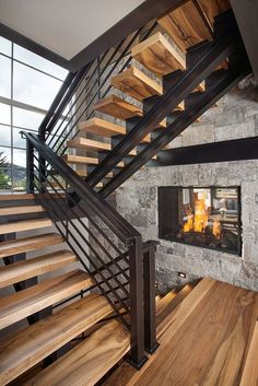 a fire place in the middle of a room next to a stair case and window