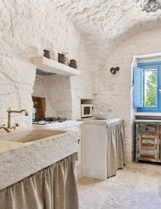 a kitchen with white walls and stone floors