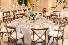 the tables are set up with white linens and gold rimmed chairs for an elegant wedding reception