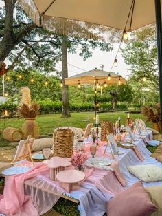 tables set up for an outdoor party with pink and blue linens on the table