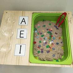 a child's sand tray with letters and numbers in it