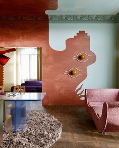 a living room filled with furniture and walls painted in different shades of pink, blue and orange