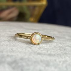 Handcrafted in 14K solid gold, features a 4mm round cab natural opal bezel set in a beautiful milgrain vintage style setting. A great everyday stacking ring or alternative gemstone engagement ring for your loved one! 🛠️ Setting: ✔️Metal Purity: 14K Solid Gold ✔️Color:  Yellow ✔️Band width: 1.5mm ✔️Ring sits 2.7mm on the finger 💎Center Stone: ✔️Stone: Natural Opal ✔️Shape: Round Cabochon ✔️Size: 4mm ✔️Carat: 0.25ct ❤️Visit our official website for exclusive new products.      https://elekalonjewelry.com/ ❤️Follow us on Instagram @ elekalonjewelry for the latest projects and much more! ❤️If you have any questions, please feel free to message us. . Classic Opal Birthstone Ring With Round Band, Gold Opal Ring With Halo, Heirloom Style Gold Opal Ring With Bezel Setting, Heirloom Gold Opal Ring With Bezel Setting, Classic Round Opal Ring, Heirloom Ethiopian Opal Round Ring, 14k Gold Stackable Opal Ring, Gold Round Cut Opal Ring, Elegant Opal Ring With Bezel Setting