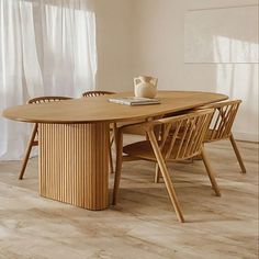 a wooden table with two chairs and a vase sitting on it's end next to a window