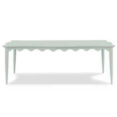 a white table with scalloped legs and a long top on the bottom, in front of a white background