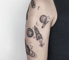 a man with a black and white tattoo on his arm that has planets around it