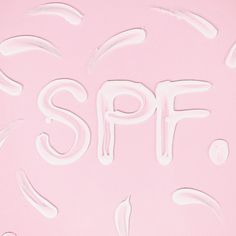 the word spf is written in white paint on a pink background with swirls